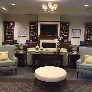 A cozy living room with comfortable seating, bookshelves, and elegant decor.