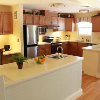 A modern kitchen with wooden cabinets, stainless steel appliances, and a central island.