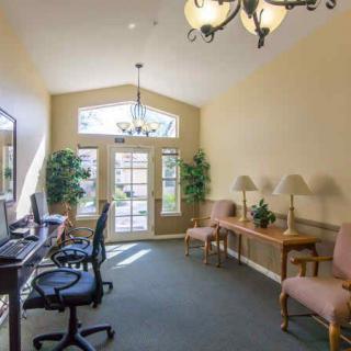 A bright office space with computers on desks and comfortable seating.