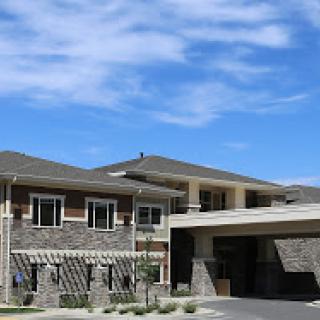 A modern residential building showcasing a blend of stone and contemporary architecture under a clear blue sky.