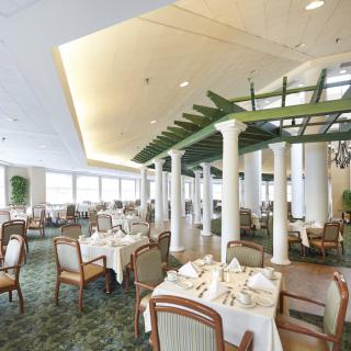 A spacious and elegantly decorated restaurant interior with neatly arranged tables and chairs.