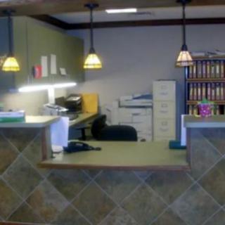 A reception desk area with office supplies and filing cabinets.