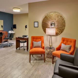 A modern lobby with vibrant orange chairs and contemporary decor.