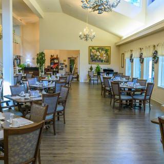 A spacious and elegantly decorated restaurant dining room with neatly arranged tables and chairs.