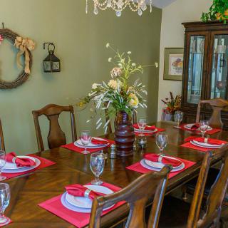 Elegant dining room with a fully set table and floral centerpiece.