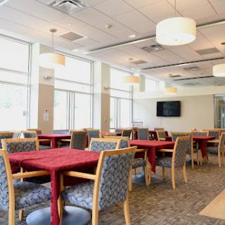 A bright and inviting dining area with red tablecloths and ample natural light.
