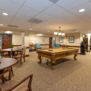 A spacious lounge with a pool table and comfortable seating arrangement.