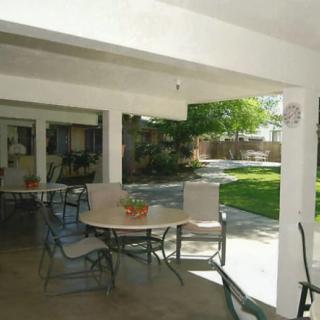 A cozy outdoor patio with seating and a view of the garden.