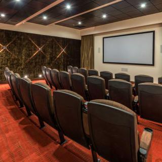A luxurious home theater with plush seating and a large projection screen.