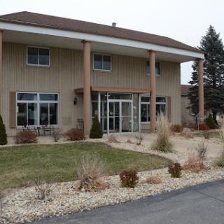 A modern two-story building with a welcoming entrance and landscaped surroundings.