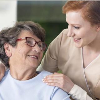 A caregiver shares a warm moment with an elderly woman, highlighting the bond of companionship and care.
