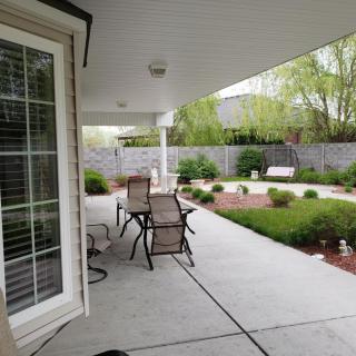 A well-maintained patio area with outdoor furniture and a landscaped garden.