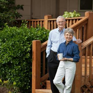 A cheerful elderly couple enjoying a moment together on their porch.