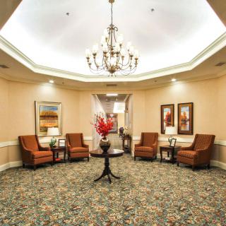 A well-furnished lobby with a chandelier, comfortable seating, and decorative artwork.