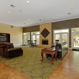A spacious living room with comfortable seating and a centrally located fireplace.