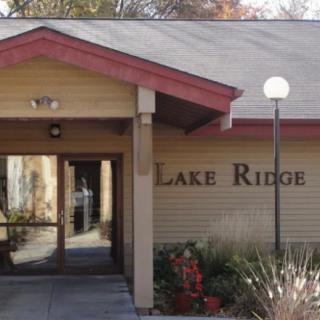 The entrance to a building named Lake Ridge, featuring its signage and surrounding exterior design.