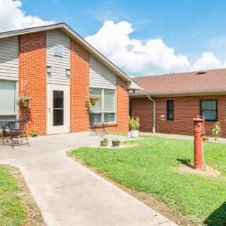 A charming residential house with a landscaped yard and a clear blue sky.