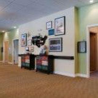 A well-lit lobby area with framed artwork and decor on the walls, featuring multiple doors.