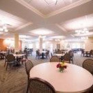 A spacious dining area with round tables and elegant lighting.