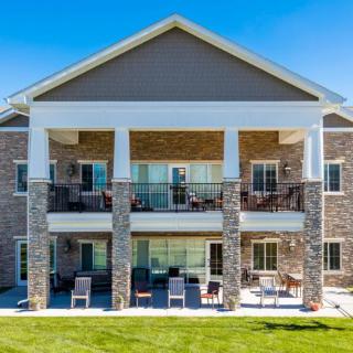 A modern residential building with a spacious lawn and balconies.