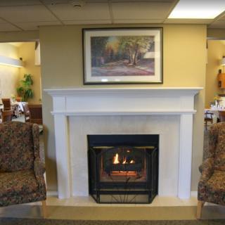 A cozy living room with a lit fireplace and comfortable seating.