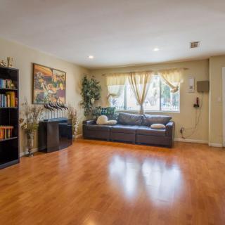 A cozy living room with a sofa, bookshelf, and hardwood flooring.