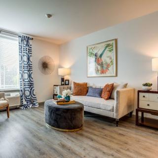 A stylishly decorated living room featuring a comfortable couch, a round coffee table, and modern lighting.