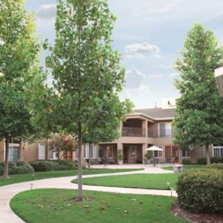 A well-maintained residential apartment complex with landscaping and a walkway.