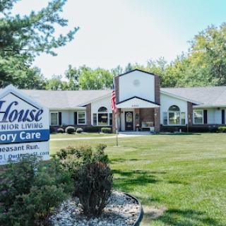 A memory care facility showcasing a welcoming exterior and well-maintained landscape.