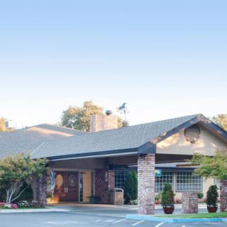A view of a suburban building with stone accents and a surrounding parking area.