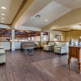 A modern and spacious lobby area with comfortable seating and wood flooring.