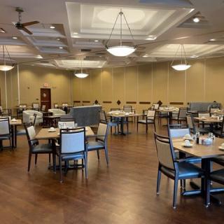 An empty dining room with neatly arranged tables and chairs, ready for guests.