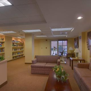 A cozy library lounge with sofas and bookshelves.