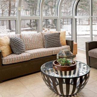 A modern living room with a comfortable sofa, stylish glass coffee table, and large windows allowing natural light.
