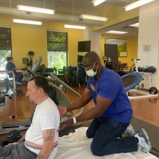 A physical therapist assists a patient during a rehabilitation session, focusing on recovery and mobility.