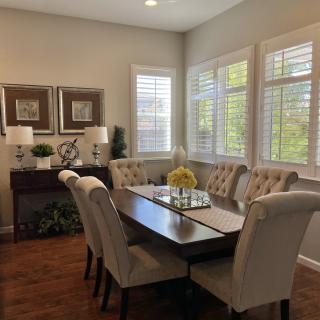 A cozy dining room with elegant furniture and ample natural light.