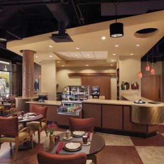 A modern restaurant interior with neatly arranged tables and chairs, featuring a cozy atmosphere.