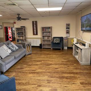 A cozy living room space featuring comfortable seating, bookshelves, and a television.