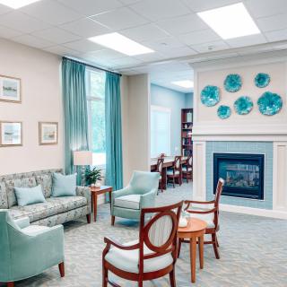 A cozy living room with stylish furniture, featuring a fireplace and blue-themed decor.
