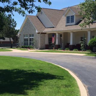 A suburban house with a well-maintained lawn and a driveway.