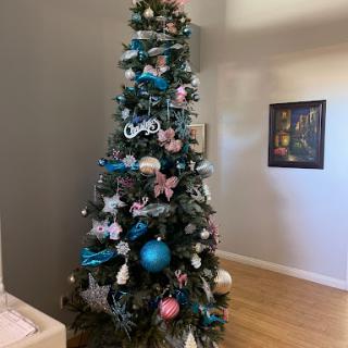 A beautifully decorated Christmas tree adorned with blue and pink ornaments, adding a festive touch to the room.