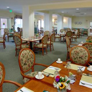 An empty dining room with elegantly set tables and floral decorations.