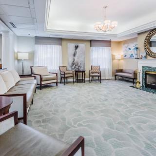A modern waiting room with comfortable seating, a chandelier, and decorative elements.
