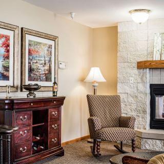 Cozy living room with an armchair, fireplace, and decorative artwork.