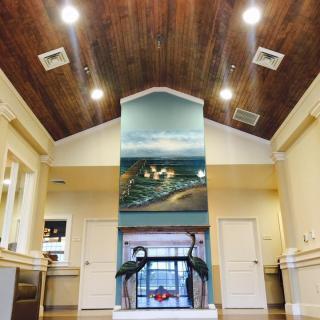 A well-lit lobby interior featuring a large mural and modern architecture.
