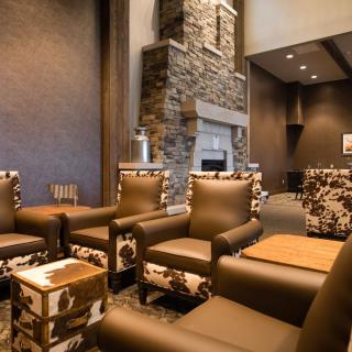 A cozy lounge with modern furniture and a stone fireplace.