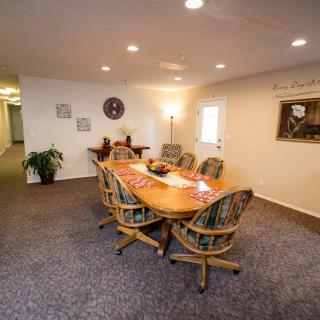 A spacious conference room with a large meeting table and several chairs, decorated with artwork and plants.