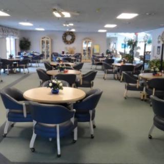 A spacious community center with multiple tables and chairs arranged for gatherings or meetings.