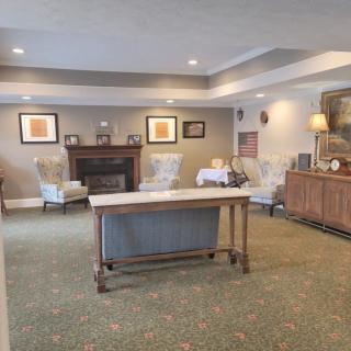A cozy living room with a fireplace, table, and comfortable seating arrangements.