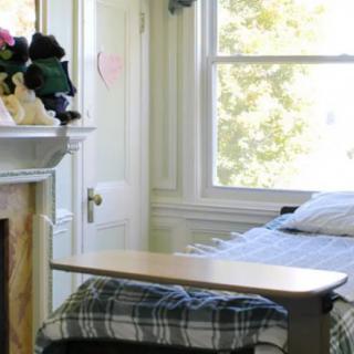 A cozy bedroom with a bed near a large window, allowing natural light to illuminate the space.